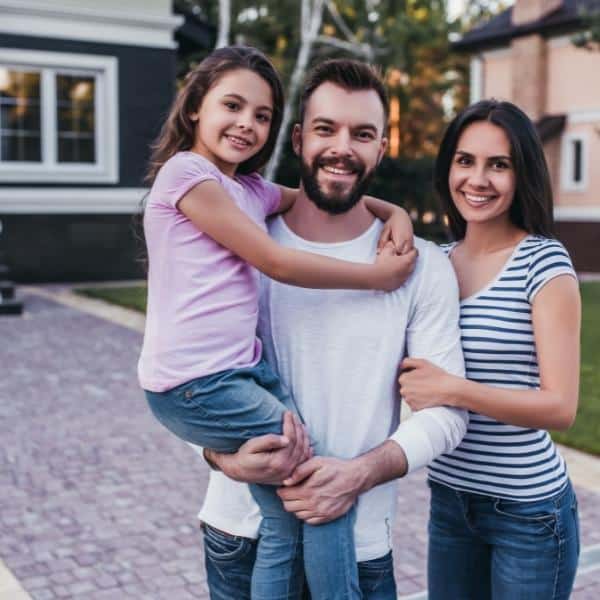 A family standing outside their new home.